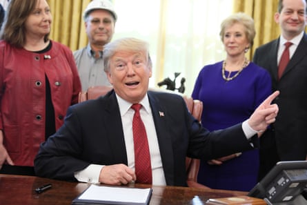 trump points backward in front of several people