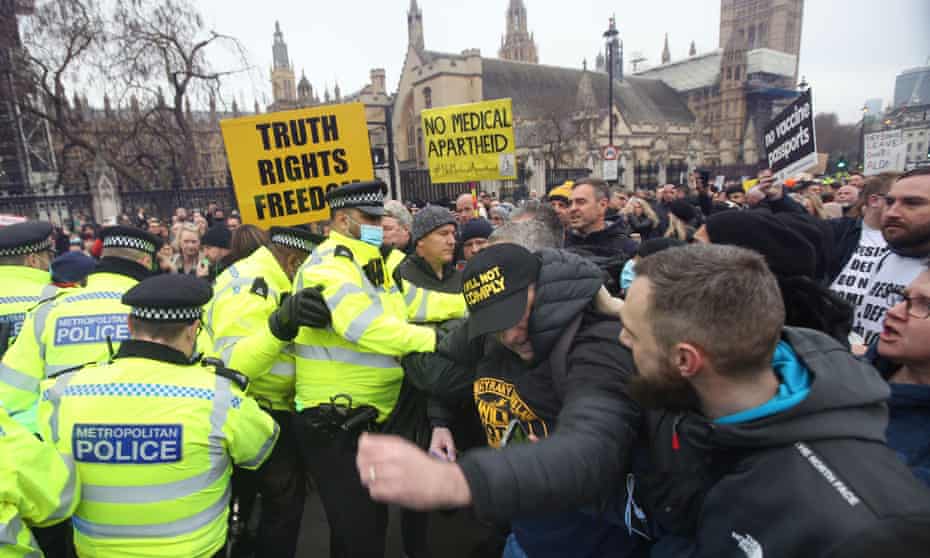 Police officers and demonstrators tussle in Parliament Square during an anti-vaccination protest.