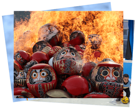 Fire engulfs a pile of round, hard-shelled doll faces