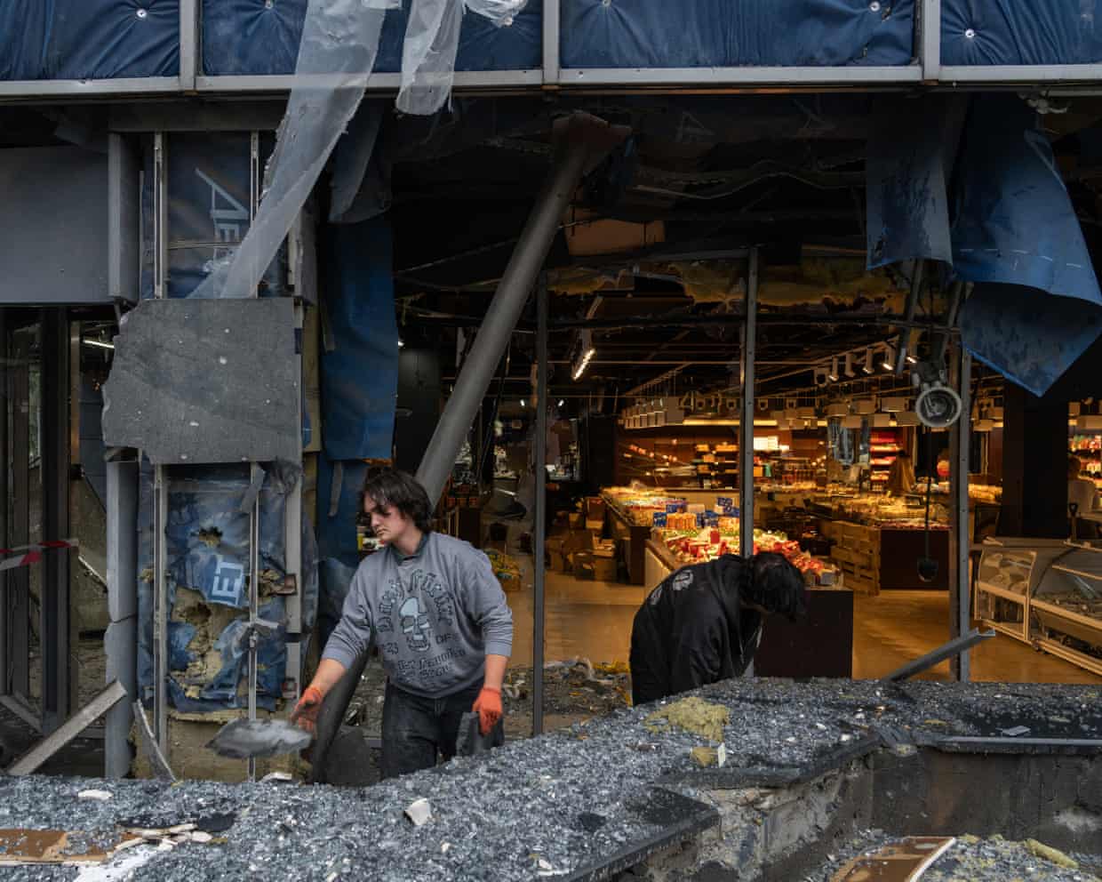 People clear debris at the site of an air attack in Kyiv.