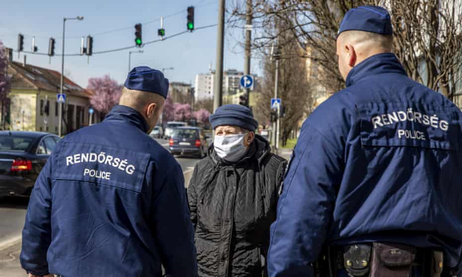 Police officers talk to a woman in Bekescsaba, Hungary on Tuesday.
