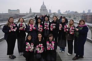 Activists holding flowers and dressed in black on Millennium Bridge in London