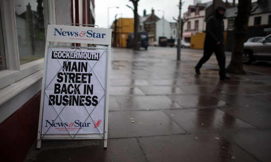 A newspaper board declares Cockermouth high street back in business after the flooding in Cumbria in 2009. 