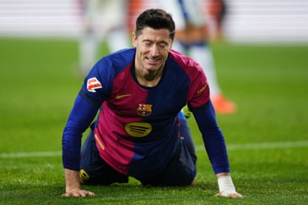 Robert Lewandowski looks dejected while lying on the turf at the Lluís Companys Olympic Stadium.