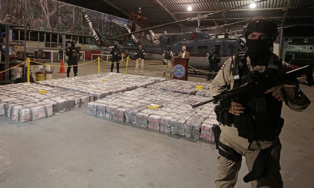 A police officer is seen in front of packages containing cocaine seized during an operation in the Caribbean, as Costa Rica’s security minister, Michael Soto, speaks to the media. 