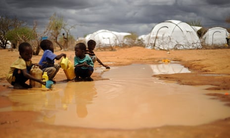 Somali boys collect water from a puddle at the sprawling Dadaab refugee complex in Kenya.