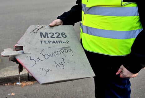 A police expert holds what authorities say is a fragment of a drone which purports to bear a handwritten inscription reading “For Belgorod. For Luch”.