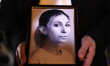 A person holds a framed photo of Viktoriia Roshchyna