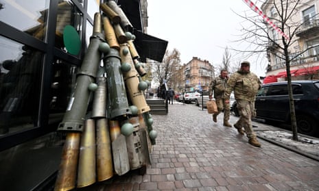 Ukrainian servicemen walk past a symbolic Christmas tree outside a cafe in Kyiv.