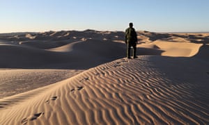 A US Border Patrol agent stands atop a dune along the US-Mexico border on 17 November 2016 near Felicity, California.