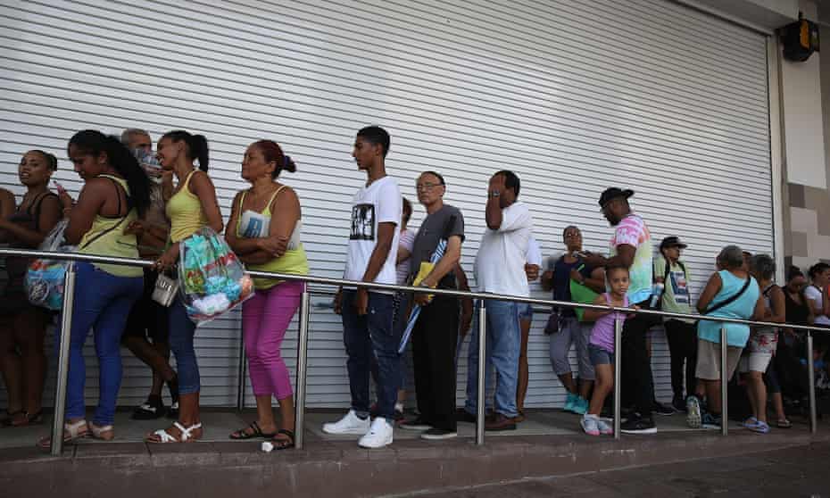 People line up to get into a Walmart store in San Juan.