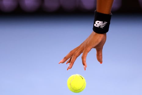 Coco Gauff's hand as she prepares to serve to Emma Raducanu.