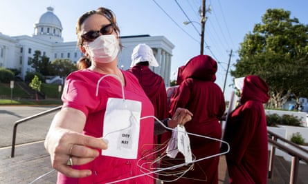 Laura Stiller hands out coat hangers as she talks about illegal abortions during a rally in Alabama.