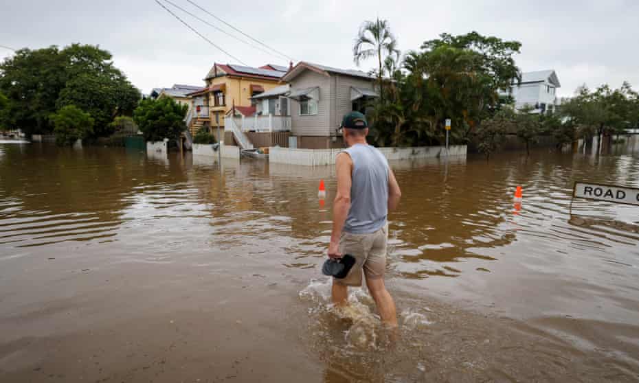 A man walks through flood waters in the Brisbane suburb of Auchenflower