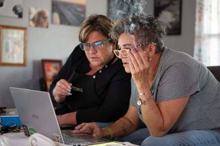 ‘It’s hell’: life under the American mobile home king who calls himself a ‘grave dancer’ Two women looking at a laptop