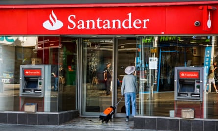 A woman stands outside a branch of Santander bank in London.