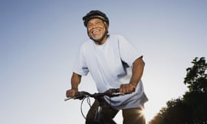 A smiling man riding a mountain bike.
