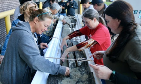 Wisconsin Historical Society maritime archaeologists Tamara Thomsen, left, and Caitlin Zant, right, and archaeologist Amy Rosebrough, second from right, carefully remove sediment from the canoe after it arrived at the State Archive Preservation Facility in Madison. 