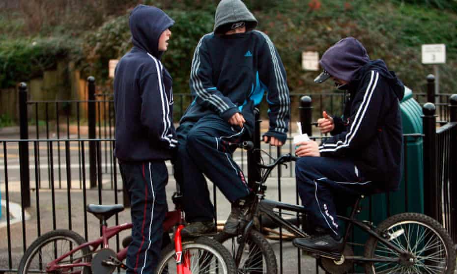 three young boys on bikes with hoodies