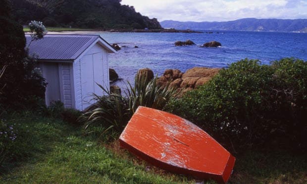 AKMJF7 Boatshed and Upturned Boat Scorching Bay Wellington New Zealand