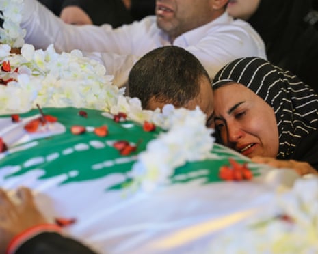 People mourn as they gather around Khalil’s coffin