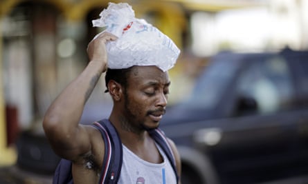 Ricki McElwee walks with a bag of his ice on his head to cool off, 25 July 2018, in Las Vegas.
