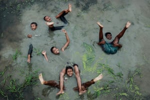 Children from a village celebrate and play in the water in Chittagong, Bangladesh during the monsoon