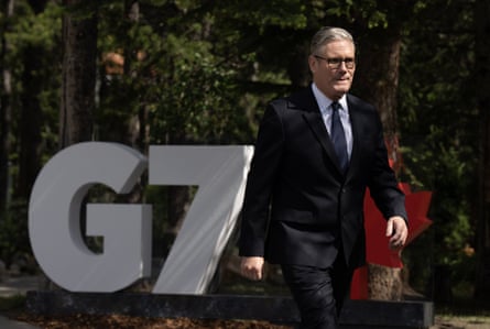 Keir Starmer walks past a G7 sign