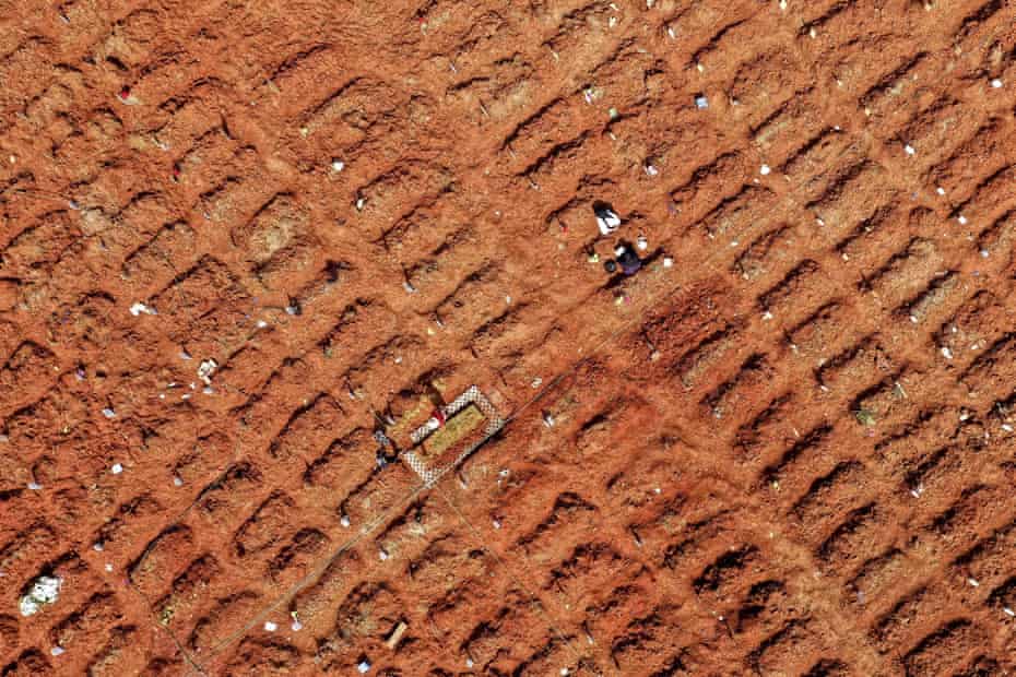 This aerial picture shows family members visiting their relative’s grave at the Pedurenan Covid-19 public cemetery in Bekasi, West Java.