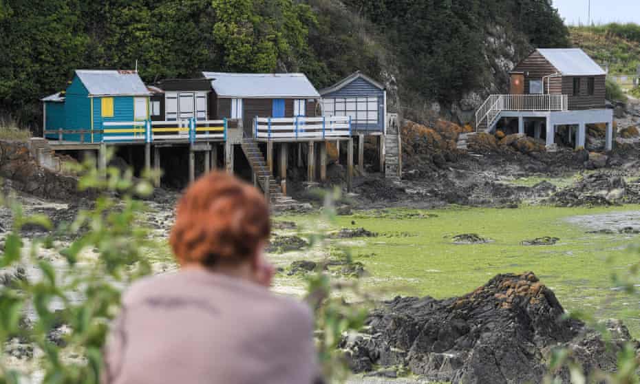 A woman looks at properties declared out of bounds due to algae at the Valais beach in Saint-Brieuc.