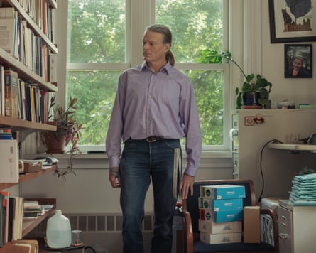 Erik Davis standing in a room looking at shelves full of books