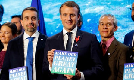emmanuel macron attending a climate event and holding a sign saying make our planet great again