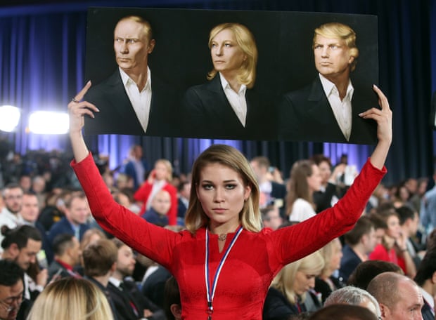 A placard adorned with portraits of Vladimir Putin, Marine Le Pen and Donald Trump is brandished by a journalist at Moscow’s World Trade Centre
