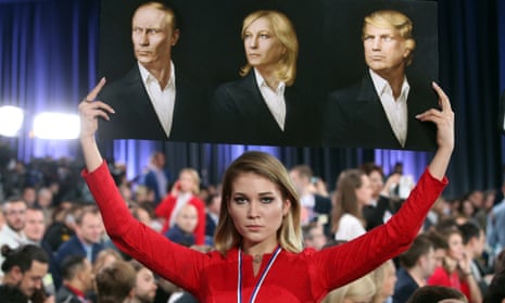 A placard with portraits of Vladimir Putin, Marine Le Pen and Donald Trump is brandished by a journalist at Moscow’s World Trade Centre in December 2016