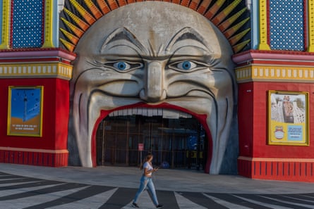 A lone person walks past the Iconic entrance of the now closed Luna Park on March 28, 2020 at St Kilda in Melbourne, Australia.