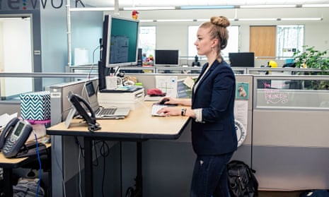 A woman standing at a desk in an office