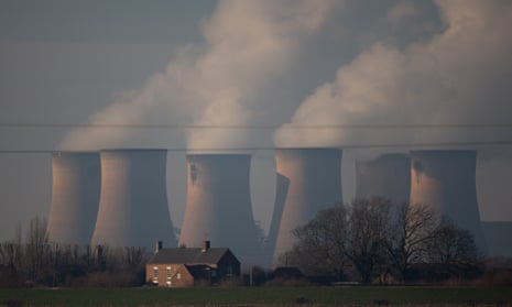 A house next to six cooling towers in a rural landscape
