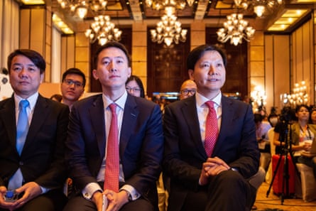 Three men sitting in opulent room in suits.