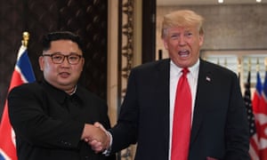 Donald Trump and Kim Jong-un shake hands.