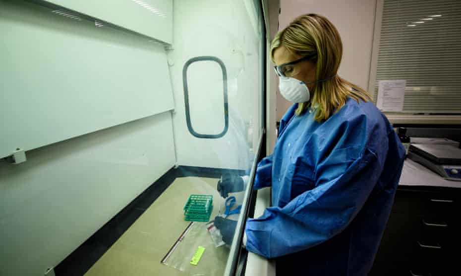 A forensic scientist processes seized narcotics, which have become increasingly dangerous as more are laced with deadly synthetic opioids such as fentanyl and carfentanil.