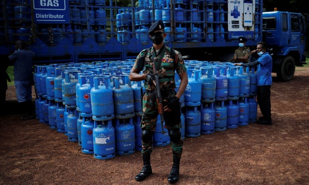 A soldier stands guard next to gas cylinders 