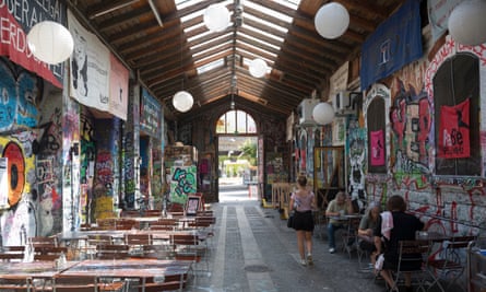 Waitress and patrons at a cafe at the Reitschule in Berne, a graffiti-covered complex that had once been a horse-riding school