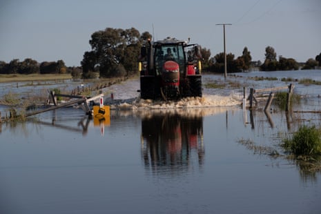 A tractor navigates a flooded road.