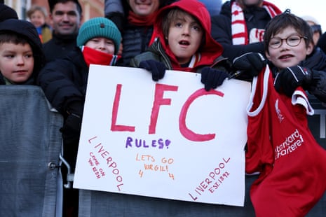 A young Liverpool fan holds a home made banner.