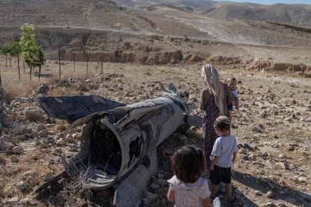 Israeli settlers look at a fallen rocket in the West Bank city of Jericho.