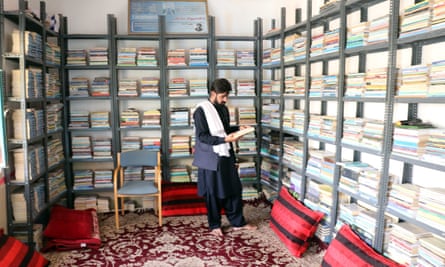 Matiullah Wesa looks over books used by volunteers in the Pen Path programme.