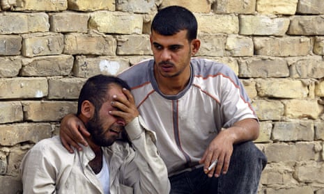 An Iraqi man weeps as another comforts him, Baghdad, April 2006