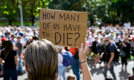 A women holds up placard during a rally to a call for action to end violence against women. The placard reads: 'How many of us have to die?’