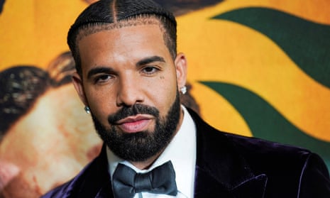 The rapper Drake wearing a dark purple velvet suit and grey bow tie
