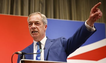Nigel Farage points while standing in front of a union jack